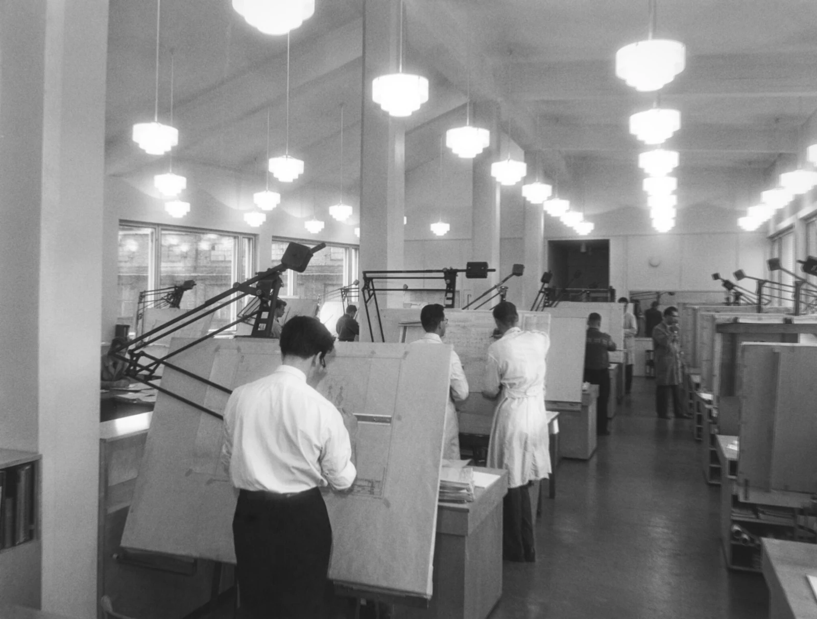 A hall of drawing boards, a class at work